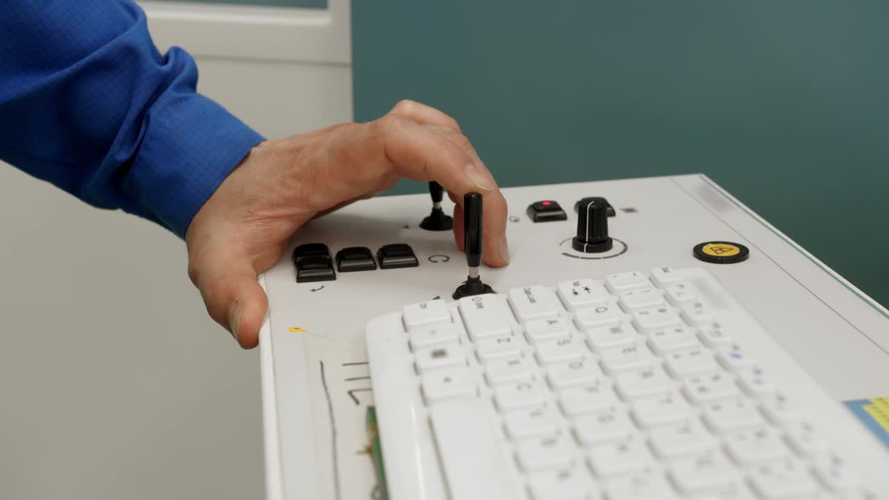 a man's hand controls the control system with a controller.