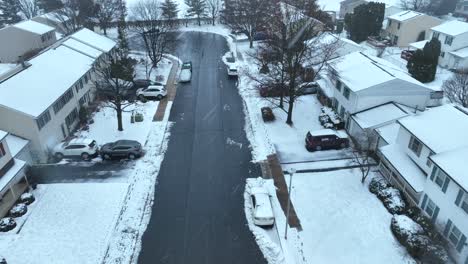 aerial flyover snowy housing area during snowfall in america