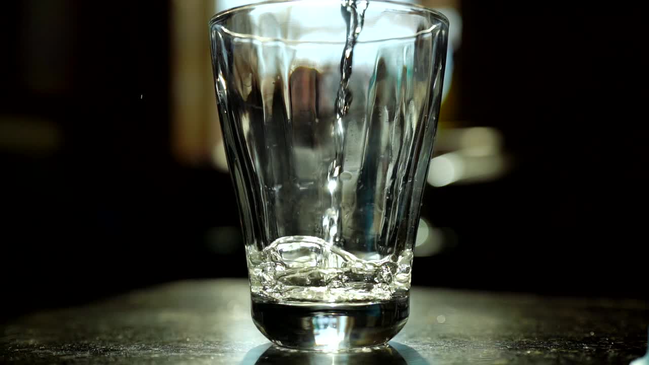 verter agua en vaso en cámara lenta