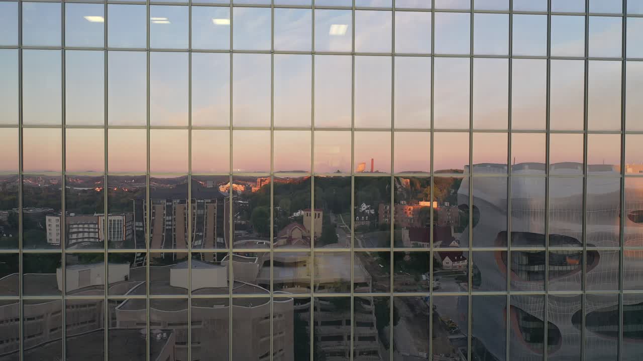 Riflesso del paesaggio urbano nelle vetrate di edifici moderni al tramonto
