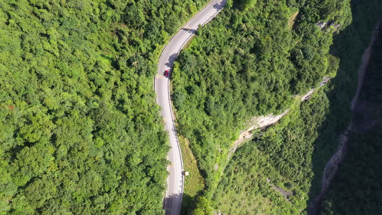 imágenes aéreas de primera vista sobre una carretera con tráfico que pasa a través de impresionantes bosques y cañones, gran altitud y carretera sinuosa, capturadas en la provincia de hebei, china