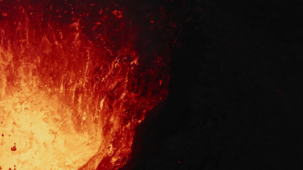 Schwenk nach oben auf den Vulkankraterrand, der heftig Lava spuckt – Drohnenansicht 4k