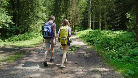 young attractive couple is walking in the forest hiking and active lifestyle