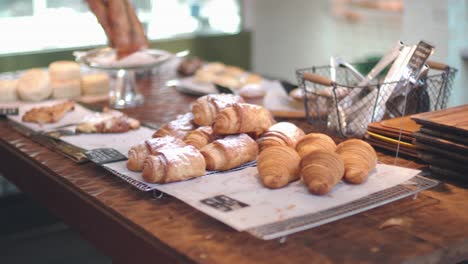 Freshly-Baked-Breads-Placed-On-The-Table-Inside-A-Bakery-In-Kyoto,-Japan---Wide-Pan-Shot