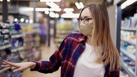 happy young woman in mask dances in supermarket, having fun