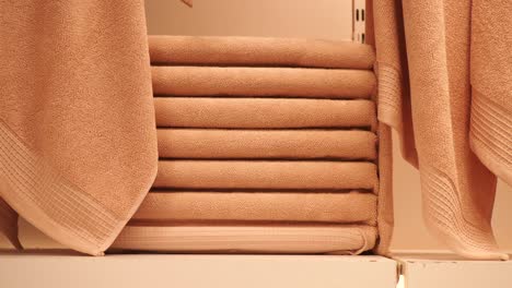 a stack of brown towels on a shelf