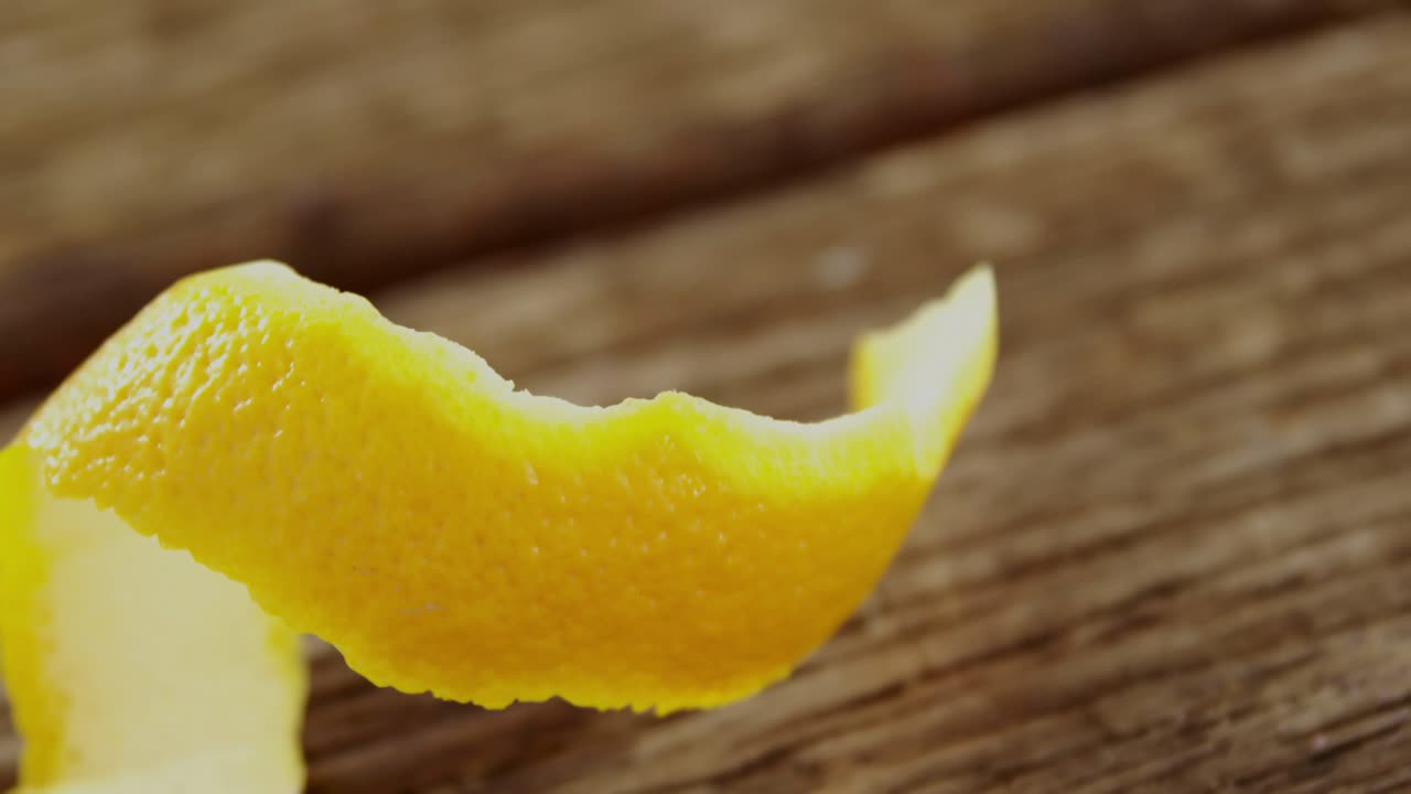 Sovrapposizione HUD che appare, scorza di agrume giallo arricciata che ruota e si srotola, visualizzando dati della timeline