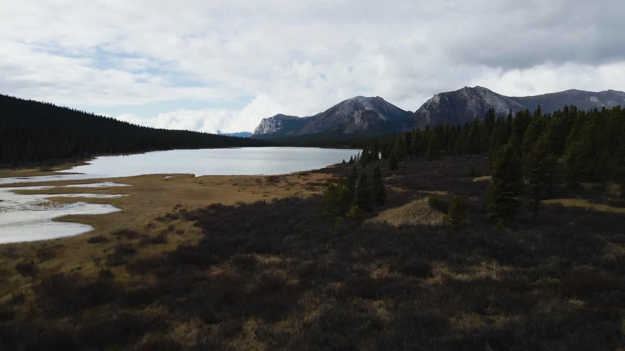 Johnson Range lake in winter at shallow lake edge, aerial drone shot