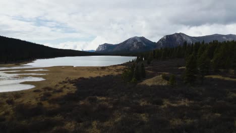 Johnson-Range-lake-in-winter-at-shallow-lake-edge,-aerial-drone-shot