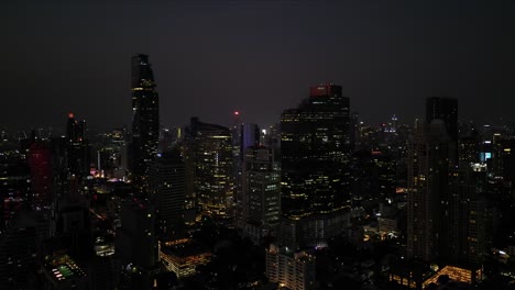 Vista-De-Pájaro-Del-Magnífico-Horizonte-De-Bangkok-Por-La-Noche,-Capturado-A-Través-De-Fascinantes-Imágenes-De-Drones