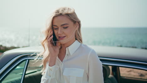 closeup girl speaking telephone standing sunny ocean coast near retro automobile