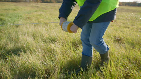 employee using calibrated rope and plummet to estimate project land size