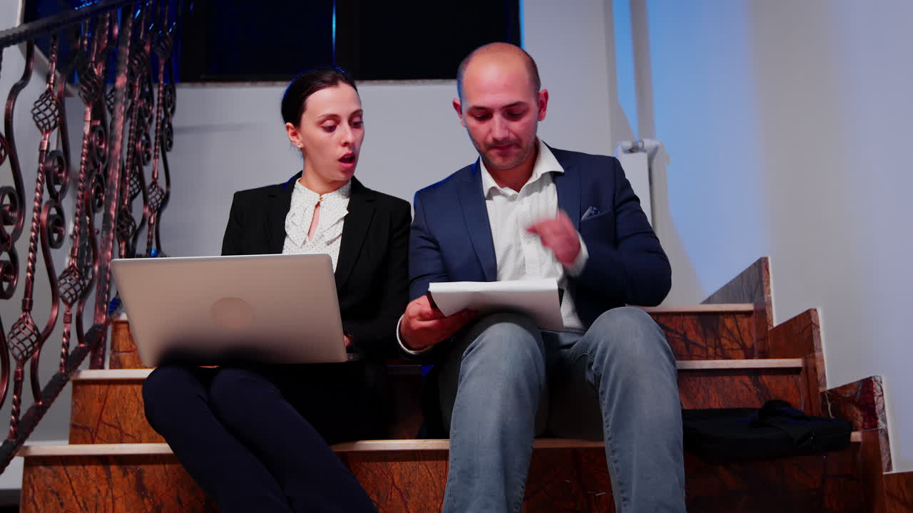 hombre de negocios haciendo horas extras ayudando a un compañero de trabajo usando una computadora portátil