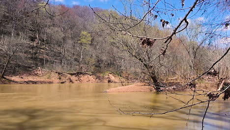 big river with dry trees mountain late winter time and blue sky background