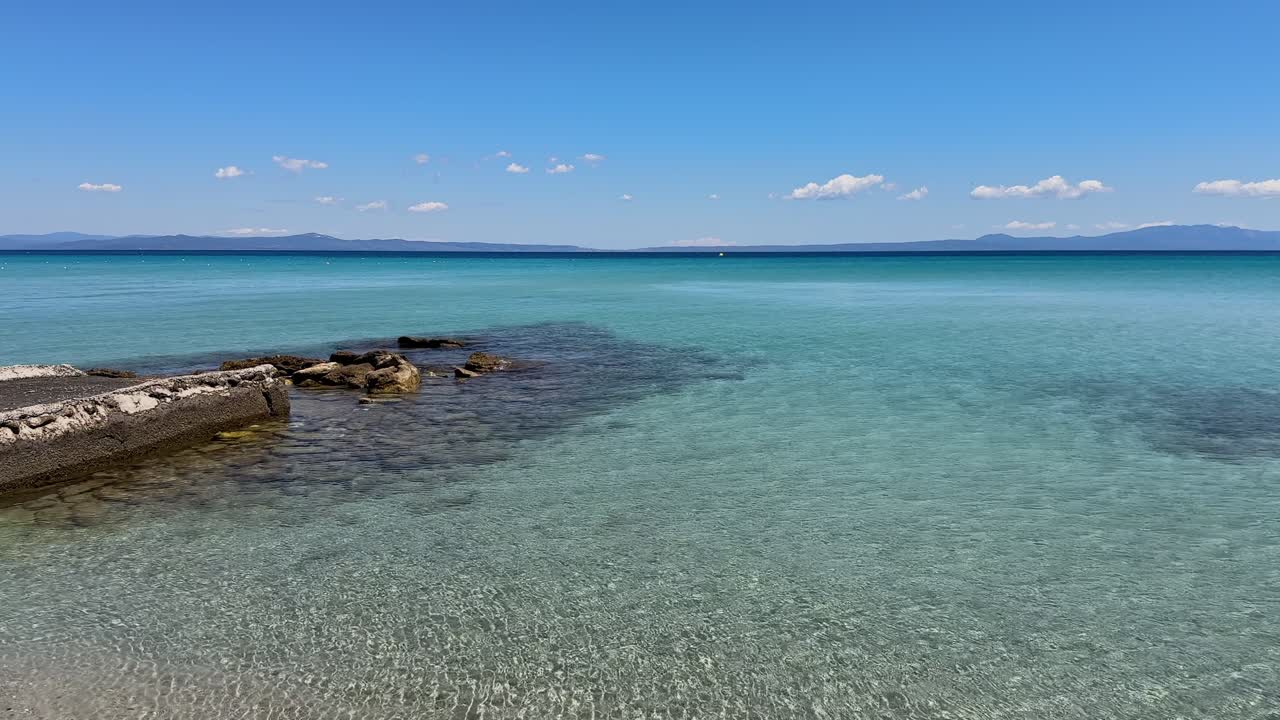 Stunning beach scene in Halkidiki, Greece, with elegant sunbeds facing the crystal-clear turquoise sea. A perfect summer escape in the heart of the Aegean.