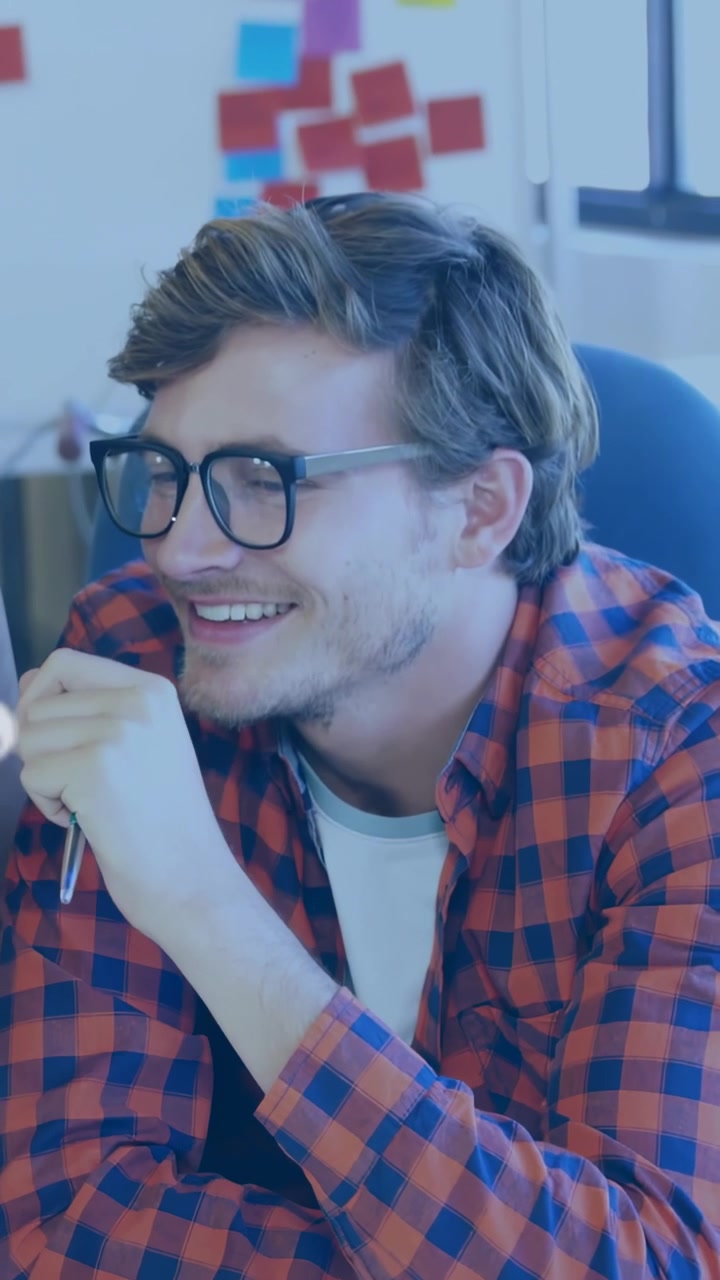 Vertical video: Seated man smiling while peer leaning in sparking network overlay for collaboration