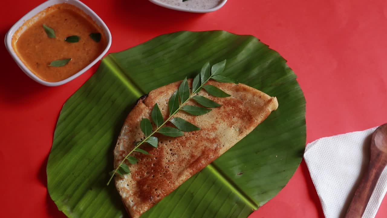 masala dosa, comida del sur de la india dosa, sambhar y chutney de coco sobre fondo rojo