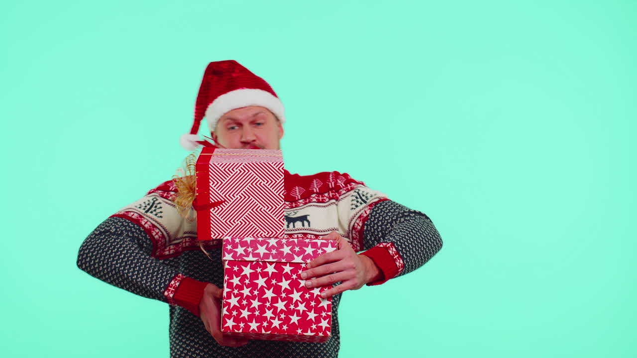 크리스마스 빨간 스웨터, 산타 모자, 미소, 많은 선물 상자를 들고 새해 선물 쇼핑