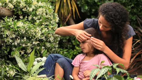 Mutter-Und-Kleine-Tochter-Stecken-Sich-Blumen-Ins-Haar