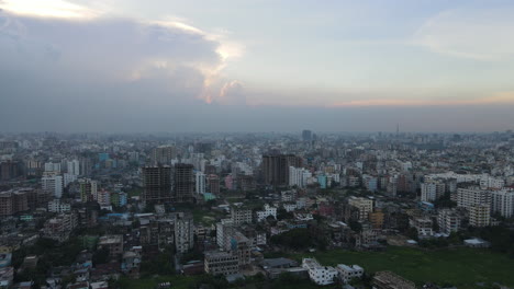 drone flying forwards revealing mega city full of buildings in india at dusk