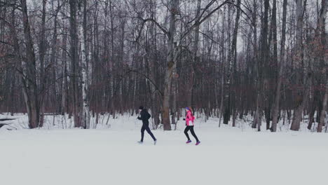 Man-and-woman-in-the-winter-running-through-the-Park-in-slow-motion.
