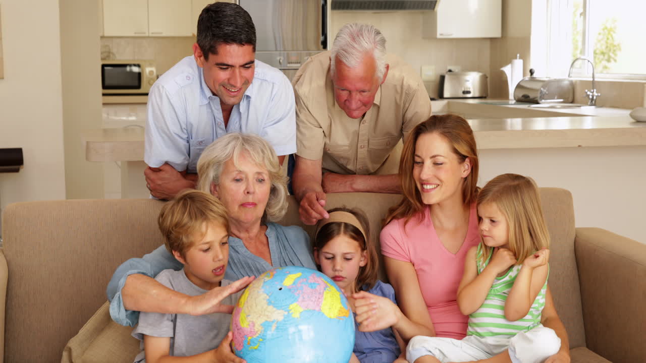 familia extendida mirando el globo juntos en el sofá