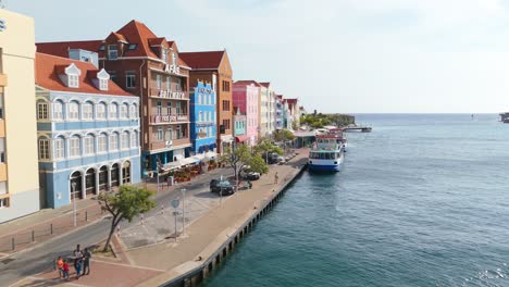 aerial appraoch establishes punda district in curacao with waterfront buildings and calm blue water in the foreground