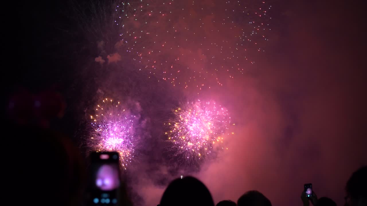 People filming beautiful fireworks on their smartphone