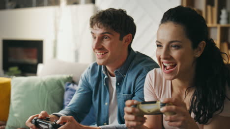 videogaming couple having fun together sitting sofa close up. wife rejoicing win