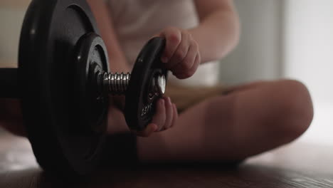 curious toddler removes gear detail from heavy barbell