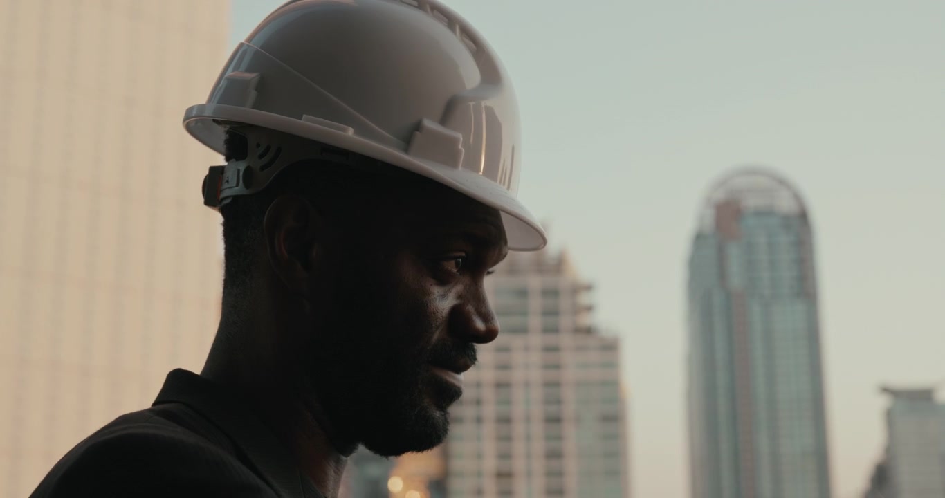 Ingeniero profesional poniéndose casco de seguridad con el horizonte de la ciudad de fondo