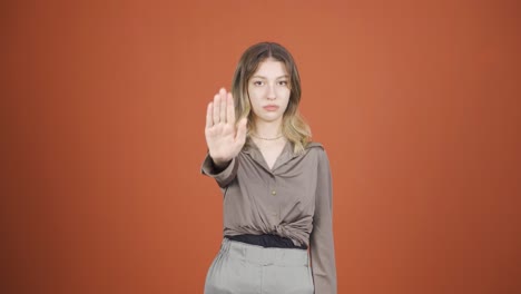 young woman making stop sign for camera.