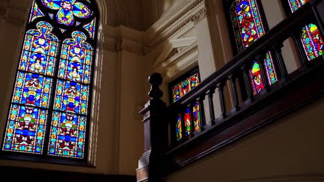 grand staircase with stained glass windows in a historic building