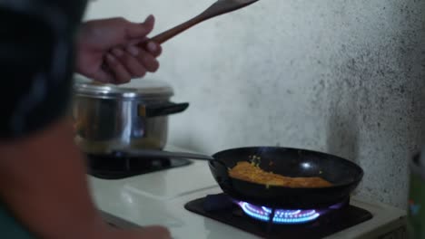 hot fry pan with fried egg placed on blue gas flame stove, filmed as medium close up shot in slow motion