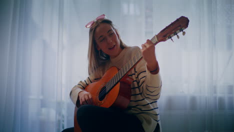 woman playing guitar writing song composing music