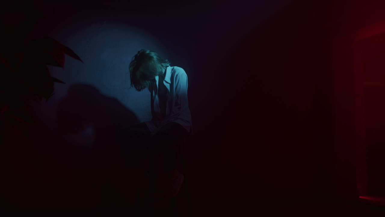 Woman Sitting in a Neon Lit Room