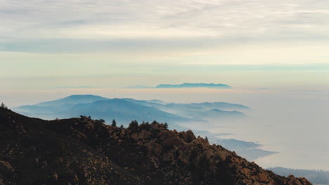 mountain range overlooking the ocean coast with clouds rolling over the sea time lapse