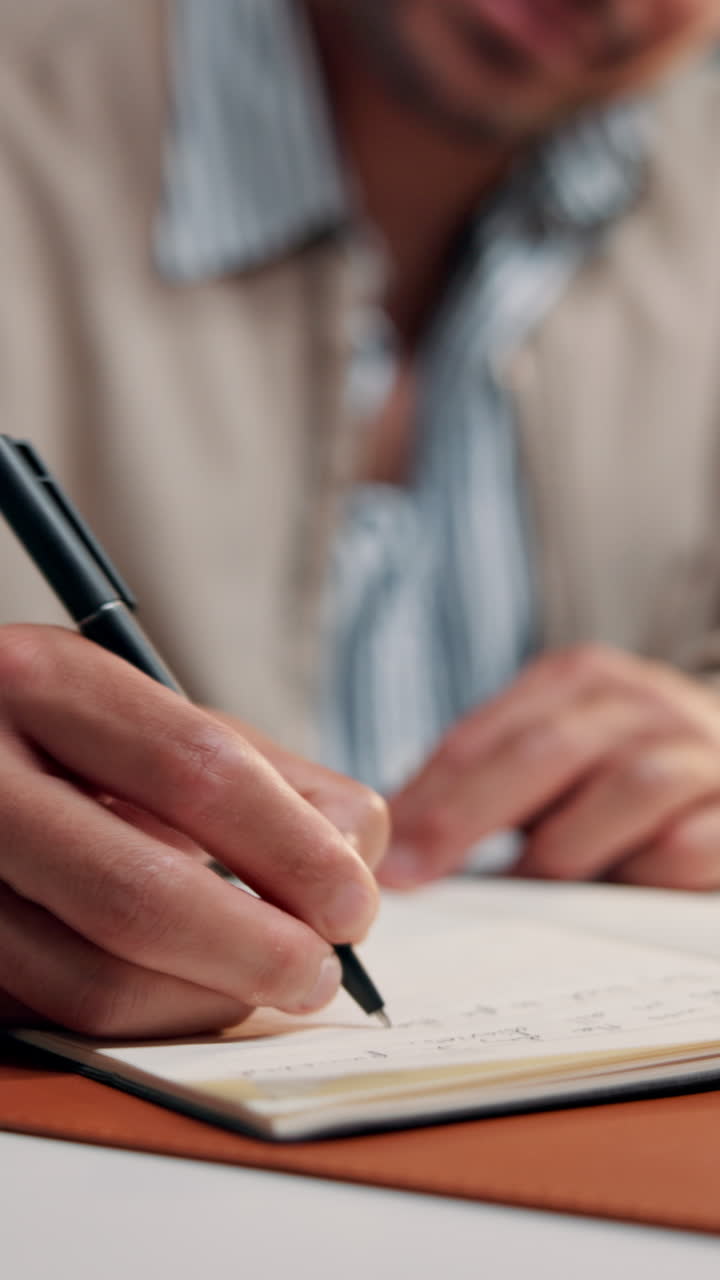 Close-Up of Person's Hand Writing in a Notebook with a Pen