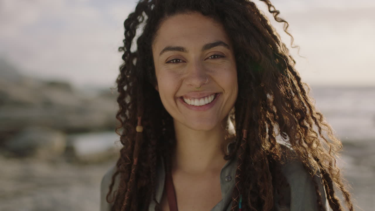 retrato de una mujer de raza mixta feliz sonriendo alegremente en la playa