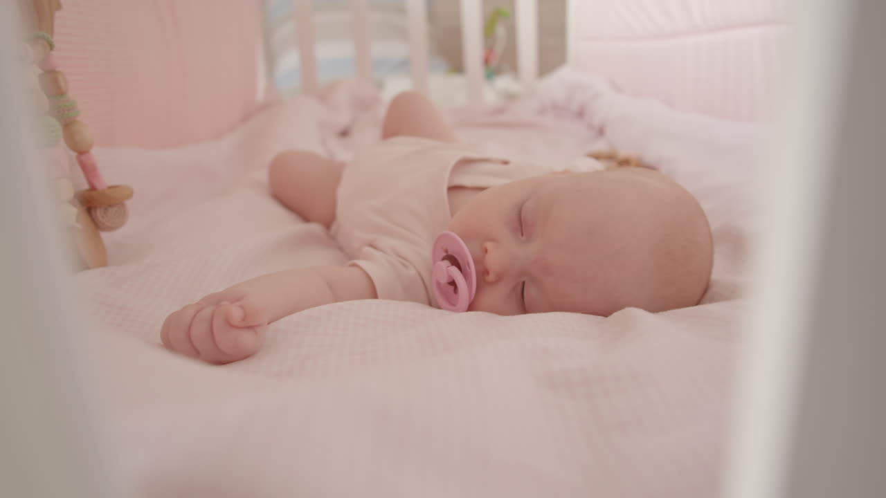 Bambino che dorme nella culla rosa