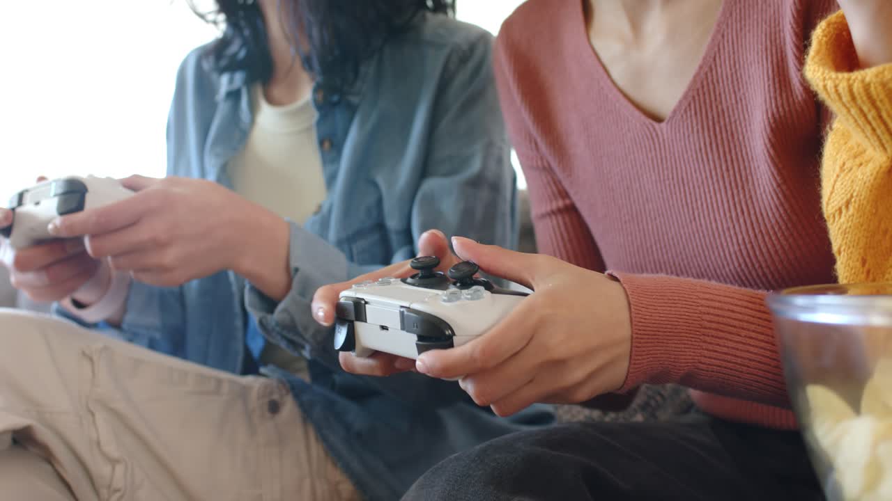 Amigo à direita ajustando a pegada, pressionando os controles, pegando batatas fritas e continuando o jogo