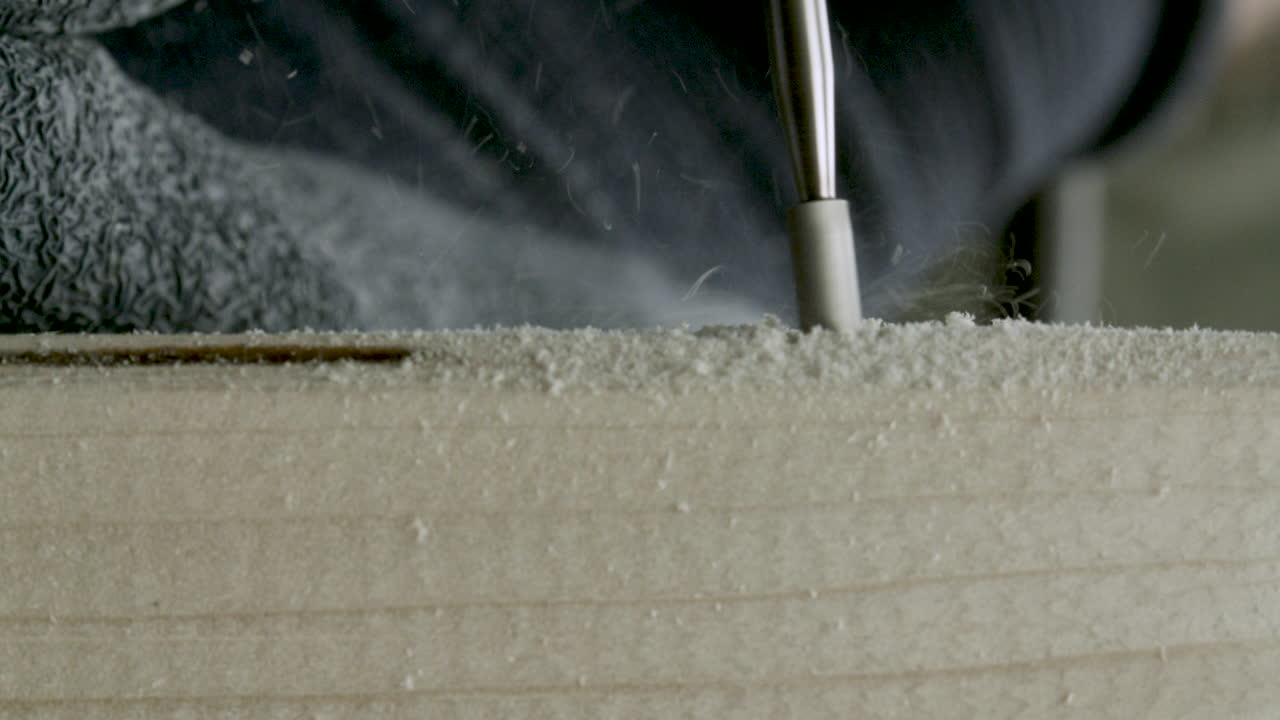 나무 조각에 조각된 장식을 만들기 위해 전기 조각 도구를 사용하는 목공예가, 클로즈업