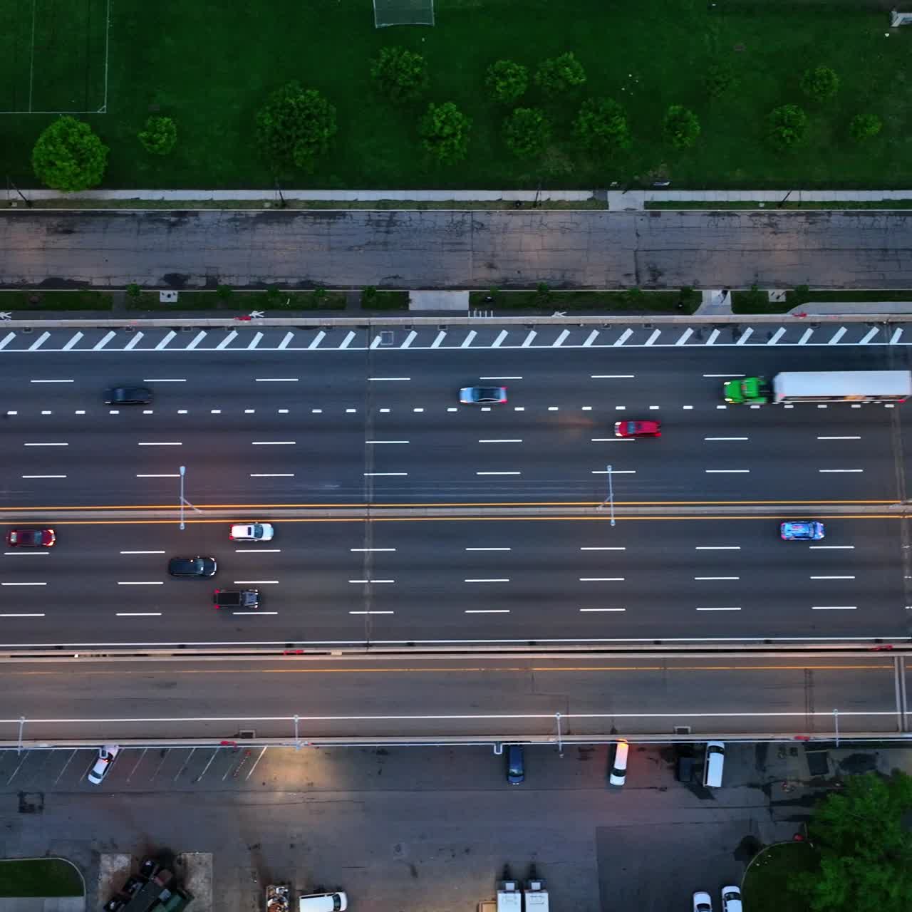 Two directions multi-lane highway in New York. Road leading to the bridge with parking lot under. Birds' eye perspective