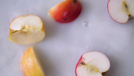 Slice-of-apple-falling-into-milky-water-with-splashes-in-slowmotion
