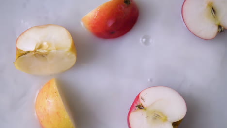 slice of apple falling into milky water with splashes in slowmotion