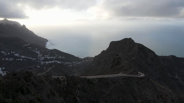 Strada di montagna tortuosa con vista panoramica sulla costa di Tenerife in una giornata nuvolosa