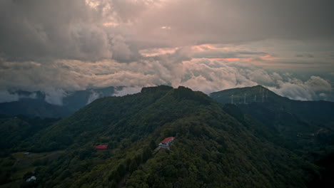 Clouds-moving-fast-over-a-green-hill-dense-vegetation-wind-turbine-costa-rica