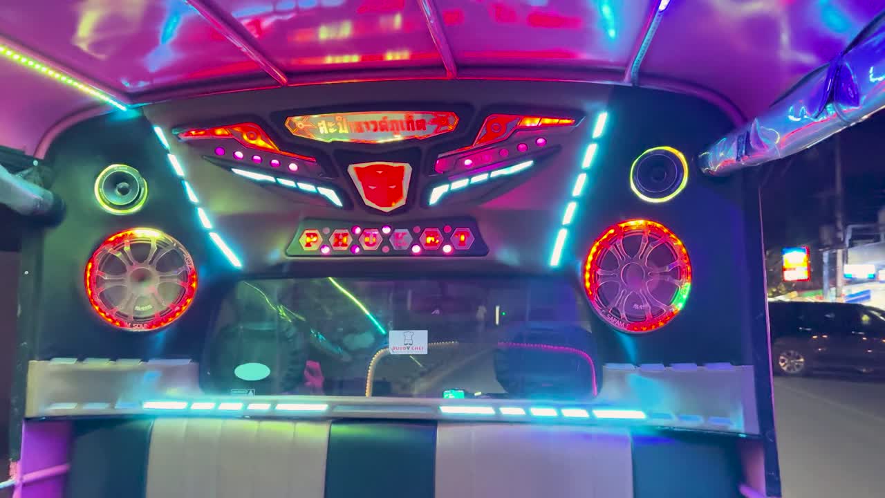Un viaggio colorato all'interno di un taxi thailandese illuminato al neon, che mostra un'illuminazione dinamica e un'atmosfera vibrante della vita notturna.