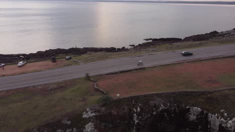 Ciclista-Pedaleando-A-Lo-Largo-De-La-Carretera-Panorámica-Y-Costera-Que-Cruza-La-Península-De-Punta-Ballena-En-Uruguay