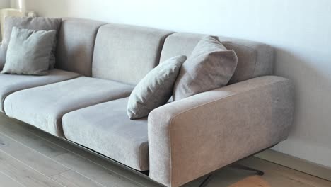 modern grey sofa with pillows in living room at home high quality photo